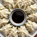 Plate of dumplings with soy sauce.